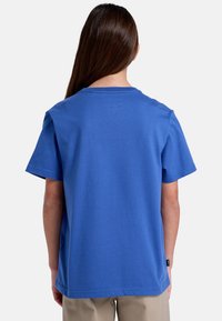 Kortærmet blå t-shirt med rund hals, lavet af bomuld, med et ensfarvet design og et mærke på den nederste venstre søm.