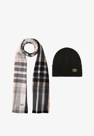 Zwarte gebreide muts met geribbelde textuur, gecombineerd met een geplaid sjaal in grijs, roze en zwarte tinten. De sjaal heeft een gouden logo-detail.