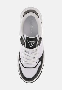 Sneaker blanc et noir avec des matériaux en mesh et en daim, présentant un logo noir proéminent sur la languette et des lacets blancs. Semelle extérieure texturée.