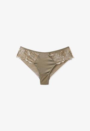 String en dentelle beige avec un centre en tissu doux. Présente de la dentelle florale sur les côtés et une texture superposée. Conçu pour une silhouette ajustée.