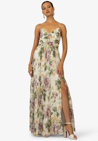 Blomstret maxikjole med fitted liv, spaghetti-stropper og en høj slids til låret. Har et miks af lilla og gule blomsterdesigns på en lys baggrund.