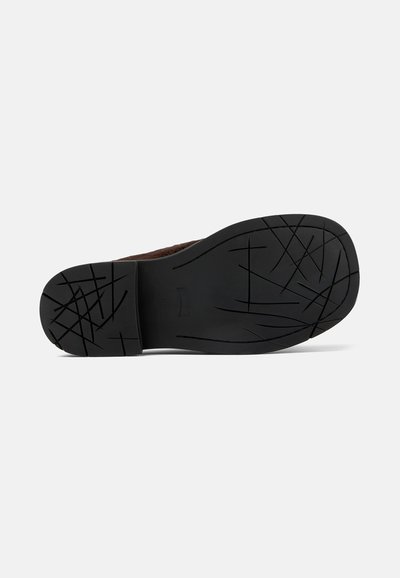 Suola di scarpa in gomma nera con un motivo di grip testurizzato e lati curvi. Presenta una punta arrotondata e dettagli minimi.