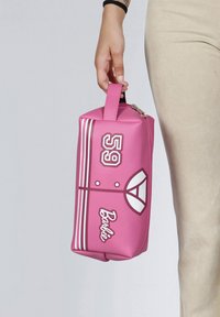 Bolso de cosméticos sintético rosa con forma rectangular, que presenta rayas blancas, un gráfico de "59" y el logo de "Barbie" en el frente. Con cremallera en la parte superior y asa.