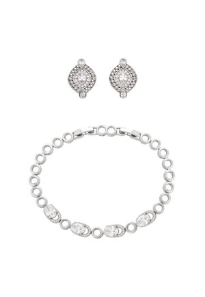 Brățară argintie cu zale circulare și accente de cristal oval, asortată cu cercei argintii cu cristale în formă de lacrimă și ovală.