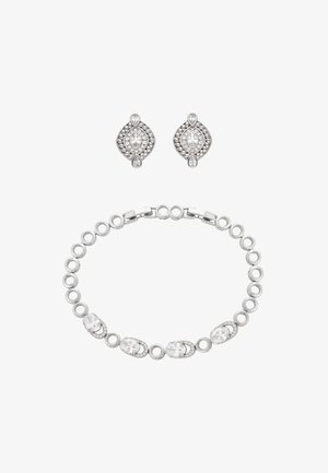 Brățară argintie cu zale circulare și accente de cristal oval, asortată cu cercei argintii cu cristale în formă de lacrimă și ovală.