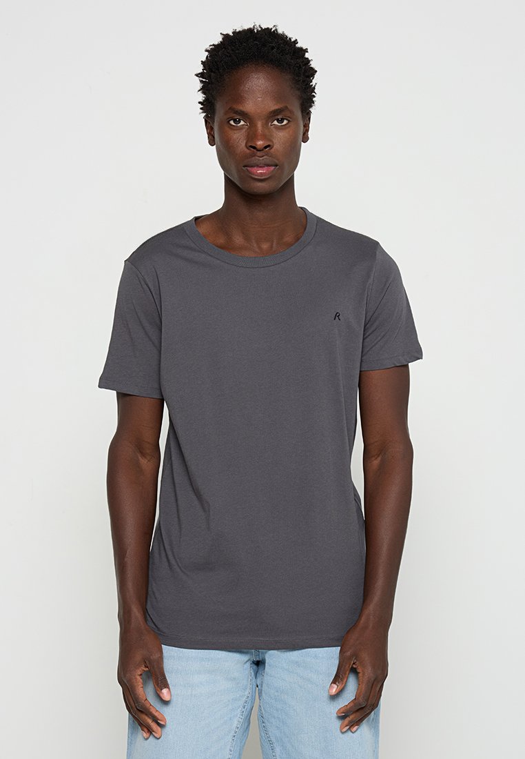 Szara bawełniana koszulka z okrągłym dekoltem i krótkimi rękawami, z małym czarnym logo na lewej piersi. Prosty, jednolity wzór.