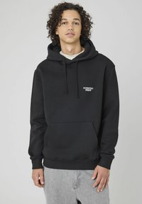 Sweatshirt à capuche noire avec poche frontale et "POTENTIAL INSIDE" brodé en blanc. Comprend des cordons de serrage et des poignets côtelés.