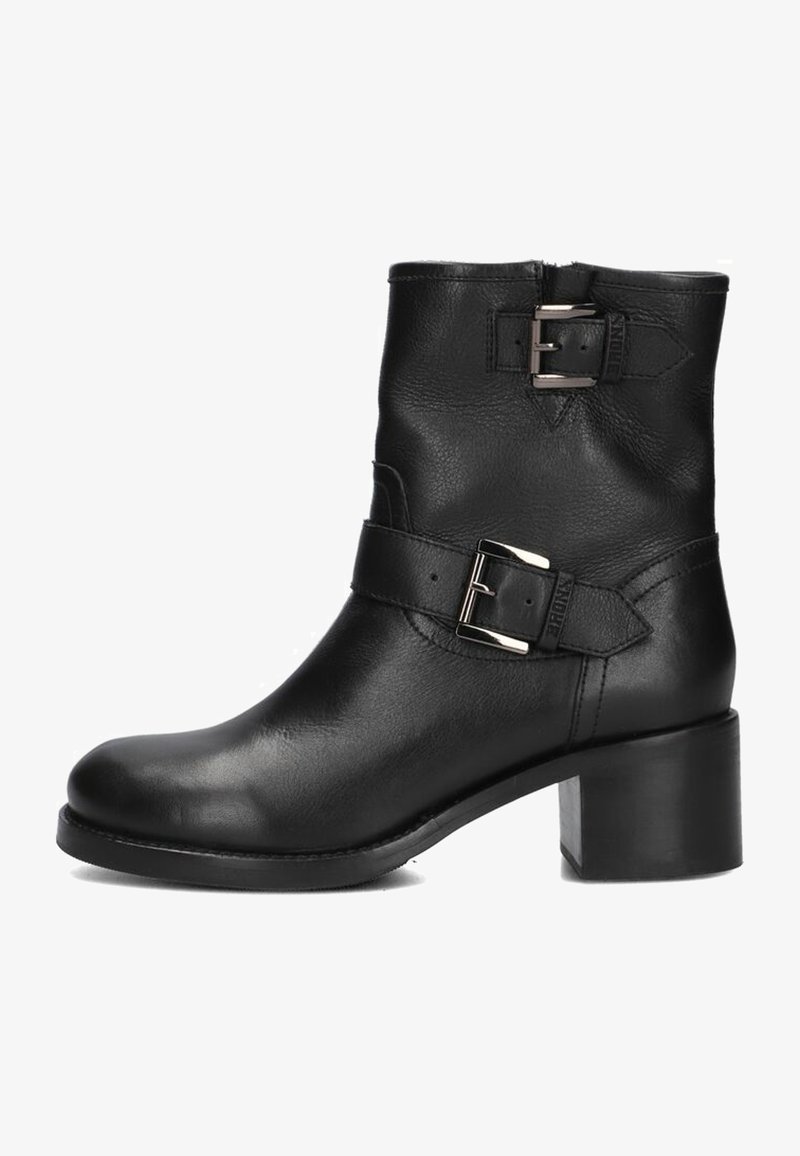 Bottines en cuir noir avec un talon block, deux boucles sur les côtés et une texture lisse. Fermeture éclair à l'arrière pour un enfilage facile.