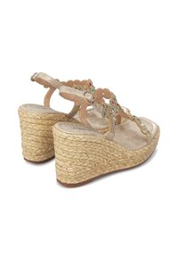 Sandalias de cuña beige con tacón de yute trenzado, decoradas con gemas florales de colores y un diseño de tira con borde ondulado. Plantilla suave y hebilla ajustable.