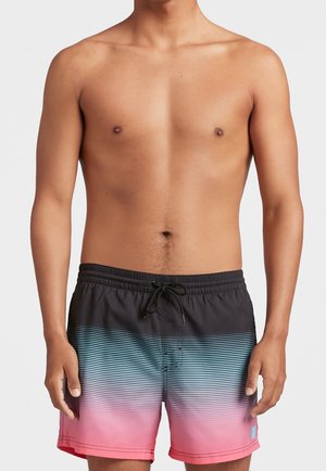 Torace maschile con pantaloncini da bagno a righe sfumate nere, blu e rosa con coulisse in vita su sfondo bianco semplice.
