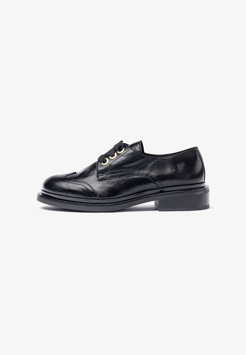 Black leather shoe with a round toe, raised stitching, decorative loops, and a flat heel. Smooth texture with a shiny finish.