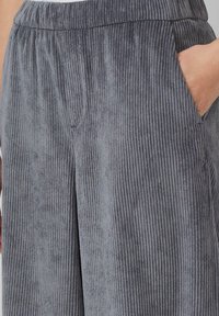 Grau Samtpantalons mit vertikal geripptem Muster, elastischem Bund und Seitentaschen, mit einer lockeren Passform und weicher Optik.