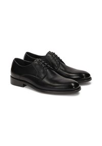 Zapatos de dress negros de cuero con un acabado suave, puntera redondeada y cuatro ojetes para los cordones. Presentan un tacón de perfil bajo.