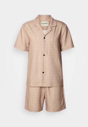 Conjunto de pijama de manga curta e colarinho em tecido rosa claro com um padrão geométrico. Apresenta um bolso na camisa e botões castanhos.