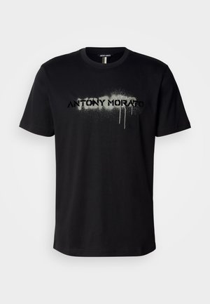 Black cotton t-shirt featuring a sprayed-text graphic "ANTONY MORATO" in gray with dripping details, short sleeves, and a crew neckline.
