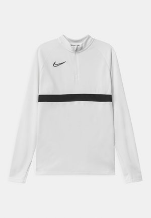 Maglia sportiva bianca a maniche lunghe con una striscia orizzontale nera e collo con zip a quarto. Presenta il logo Nike in nero nella zona sinistra del petto.