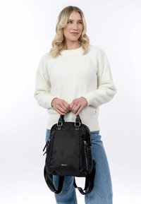 Black backpack made of nylon, featuring two front zippered pockets, dual top handles, and adjustable shoulder straps. Simple, sleek design.
