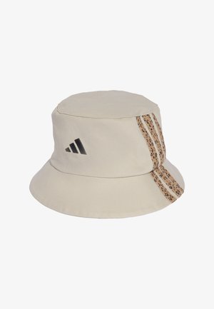 Bežna kofa kapa izrađena od pamuka s ravnim vrhom. Ima crni Adidas logo i trakasti naglasak s leopard uzorkom s jedne strane.