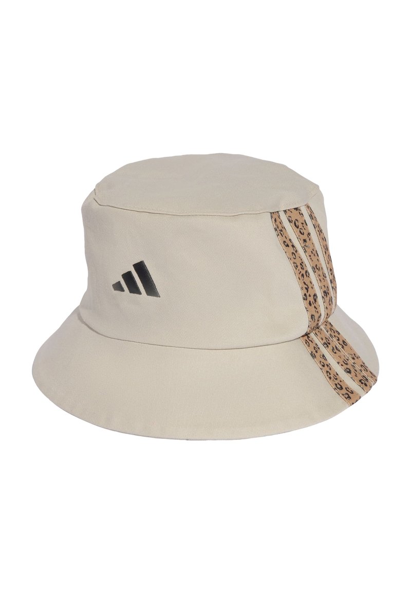 Beige bucket hat made of cotton with a flat top. Features black Adidas logo and a leopard-patterned accent stripe on one side.