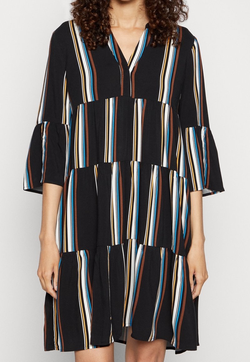 Černé šaty s vertikálními vícebarevnými pruhy v hnědé, modré a krémové barvě, s výstřihem do V a rozšířenými třičtvrtinovými rukávy.