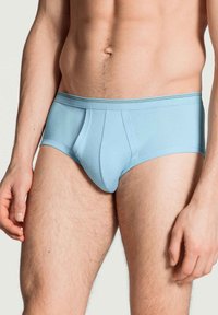 Lichtblauwe katoenen slips met een snug fit, voorzien van een gevormde pouch en een elastische tailleband. Gladde textuur zonder zichtbare patronen.