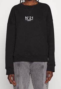 Black sweatshirt made of cotton, featuring a crew neckline, long sleeves, and a white graphic print in the center and small logo detail.