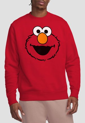 Red sweatshirt featuring a large, cartoon-style Elmo face with big white eyes and an orange nose, made from a soft, textured fabric.