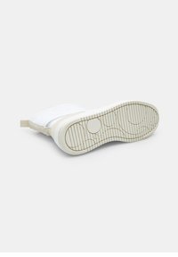 Witte sneaker met een gestructureerde rubberen zool en beige accenten, met een afgeronde vorm en een gewatteerde bovenkant, ontworpen voor comfort.