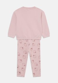 Maglione di cotone rosa con maniche lunghe e scollatura a coste, abbinato a leggings rosa con stampa di fragole in una tonalità più scura.