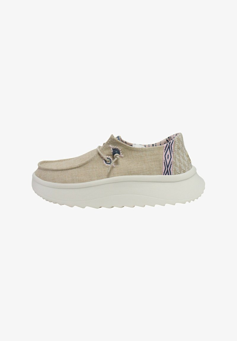 Chaussure slip-on beige avec un dessus en lin texturé, un motif intérieur coloré et une semelle en caoutchouc blanc avec un relief en vagues pour plus de traction.
