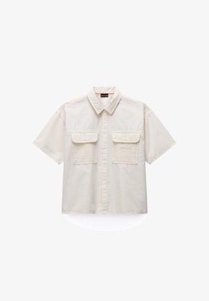 Beige shirt met korte mouwen, een kraag, een knoopsluiting aan de voorkant en twee klepzakken met knopen op de borst.