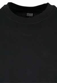 Černé bavlněné tričko s klasickým výstřihem, hladkou texturou a štítkem s nápisem "URBAN CLASSICS" na vnitřním límci. Jednoduchý design.