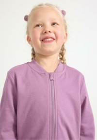 Lilla zip-up sweatshirt lavet af blødt stof, med rund krave, lange ærmer og en afslappet pasform. Lynlåsen går ned langs midten.
