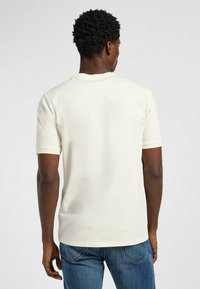 Cremefarvet kortærmet t-shirt i blød bomuld, med rund hals, synlige syninger og en afslappet pasform.