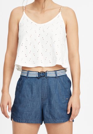 Hvid kort top med hulmønster og justerbare stropper, kombineret med mørkeblå denimshorts med et stribet bælte og dekorativt bindebånd.