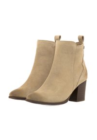 Stivaletti alla caviglia in suede beige con punta affusolata e tacco quadro. Presentano una linguetta sul retro e dettagli di cucitura minimi per un aspetto elegante.