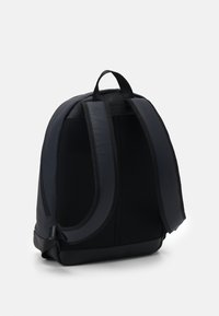 Zaino nero con schiena in mesh testurizzato, spallacci imbottiti e design elegante. Presenta una base rinforzata e dettagli in tessuto liscio.