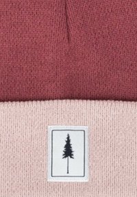 Gorro de punto con la parte superior en color burdeos y la inferior en rosa pálido. Se ha cosido un parche rectangular con un gráfico de árbol negro en la sección inferior.