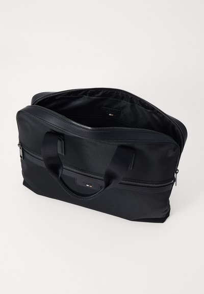 Sac à dos pour ordinateur portable noir en nylon texturé, avec des poignées doubles, une fermeture éclair et un intérieur spacieux avec un branding minimaliste.