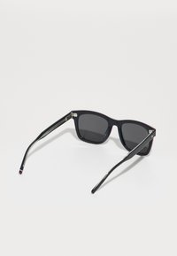 Ochelari de soare negri cu lentile închise, design unghiular al cadrului și accente metalice pe brațe. Dispun de un finisaj lucios și tije texturate.
