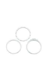 Tre anelli d'argento: uno liscio, uno con bordo a scaglie e uno incastonato con tre piccole pietre. Sono tutti circolari e presentano superfici lucide.