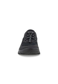 Black athletic shoe with a mesh upper, rounded toe, and thick rubber sole. Features grey laces and minimalistic design.