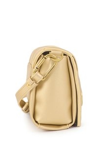 Pequeño bolso estructurado en piel dorada pálida, con una base plana, correa ajustable y accesorios en tono dorado con un detalle de logotipo en el lateral.