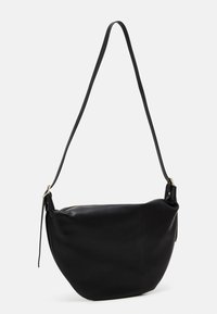 Zwarte leren schoudertas met een gebogen vorm, voorzien van een bovenste ritsluiting en een lange verstelbare schouderband. Glad textuur, minimalistisch ontwerp.