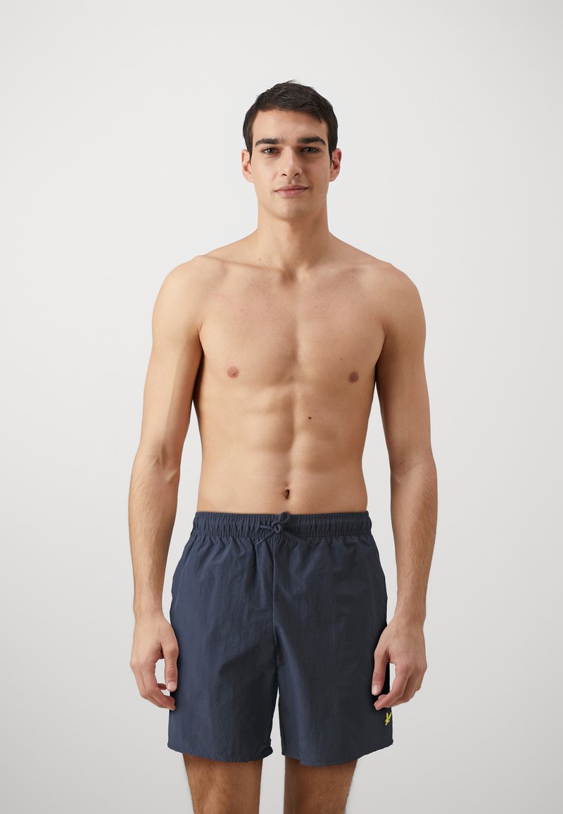 Costume de baie navy dintr-un material ușor, cu talie elastică și șnur. Design simplu, fără modele sau accente vizibile.