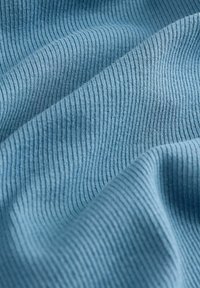 Lichtblauw geribbelde stof met een gladde textuur, voorzien van gelijkmatig verdeelde verticale lijnen en een zachte val.