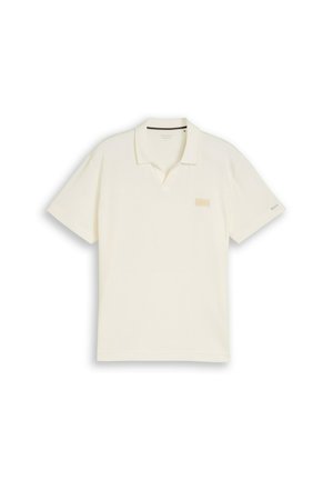 Cremefarbener Poloshirt mit kurzen Ärmeln, Kragen, kleinem Brustaufnäher und dezentem Logo am linken Ärmel.