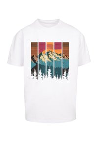 Witte katoenen t-shirt met een grafisch ontwerp van bergen en bomen met gelaagde kleuren: rood, oranje, teal en bruin in een gestileerd ontwerp.