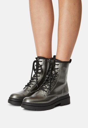 Stivaletti alla caviglia metallizzati argento con finitura testurizzata, lacci neri e suole in gomma chunky, con chiusura a zip laterale.