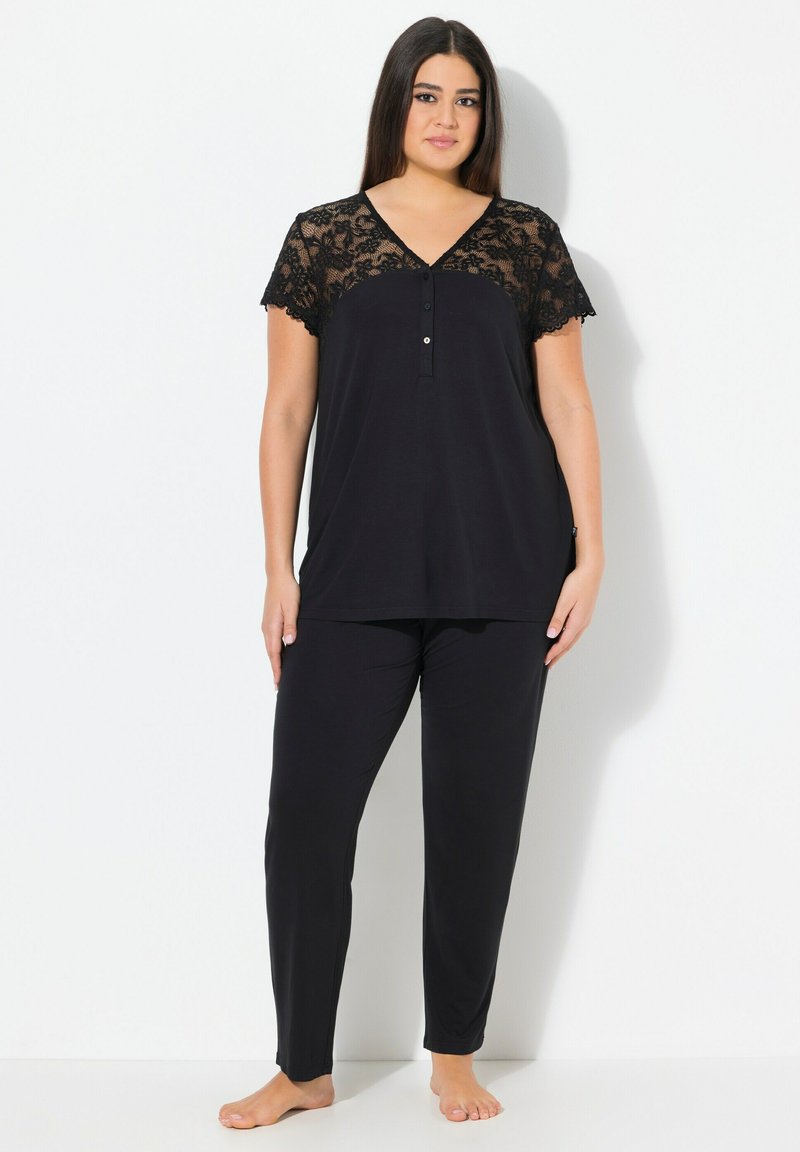 Zwart loungewear-set met een kortemouwen top met kant en knoopdetails, in combinatie met rechte broek. Zachte stofstructuur.